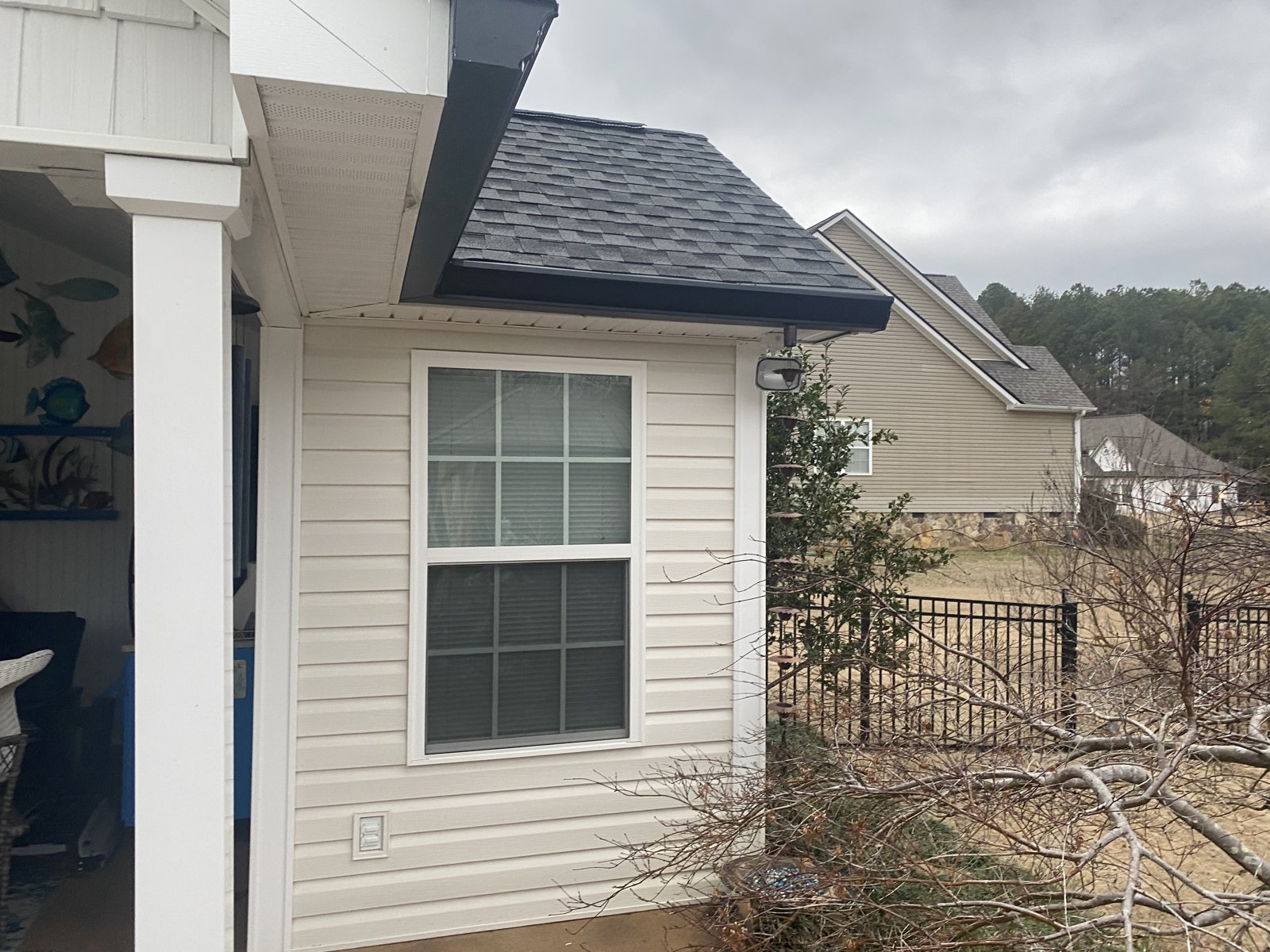 Brick home with covered porch and red door, seamless gutters installed in Fort Oglethorpe, GA