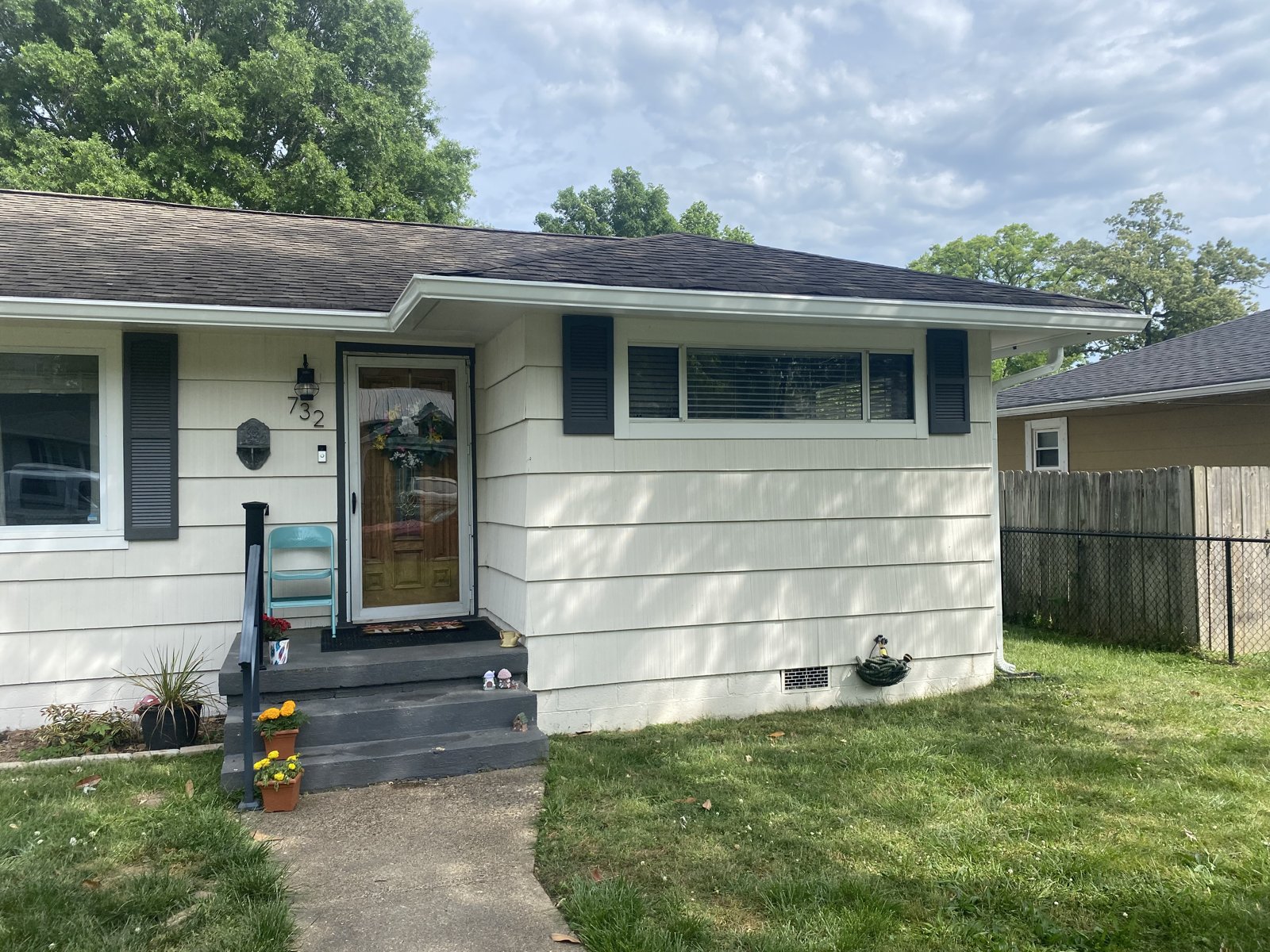 Two-story brick home with white porch and seamless gutters in Red Bank, TN