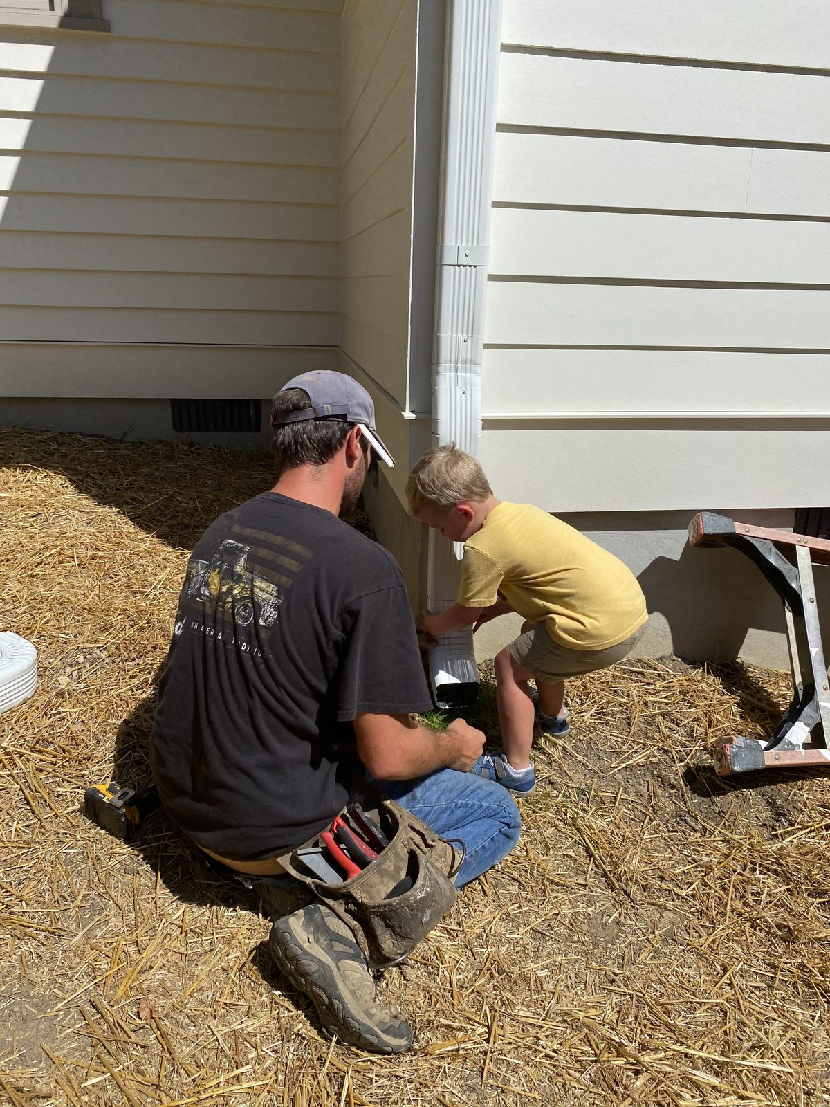 Riverbend Gutter Company owner and his son installing a downspout on a Chattanooga home